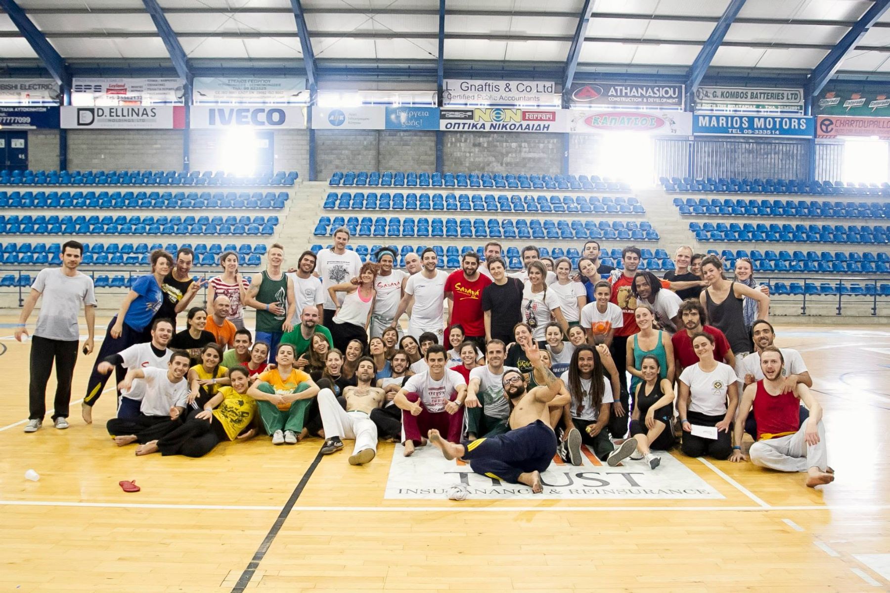 A large group of capoeiristas on a sports hall court at Cyproeira in Limassol